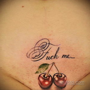 Фото тату с надписью 'Fuck me' и изображением двух спелых вишен. Рисунок выполнен в черном цвете с реалистичными деталями.