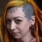 Фото тату: девушка с уникальной татуировкой в стиле кельтских узоров на голове. Рисунок татуировки выполнен в черном цвете с использованием сложных геометрических мотивов.