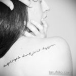 Фото тату: черная надпись 'beautiful people don't just happen' на плече девушки, выполненная каллиграфическим шрифтом. Минималистичный рисунок татуировки.
