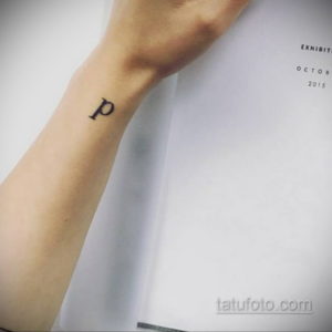 Фото тату маленькой буквы 'p' на запястье. Простой и лаконичный рисунок татуировки в черном цвете.