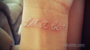 Фото тату: белая надпись 'Let it be' на пальце руки. Простой и вдохновляющий рисунок татуировки.