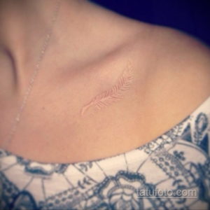 Фото белой татуировки пера на шее. Простой и элегантный контурный рисунок, подчеркивающий изящество и женственность.