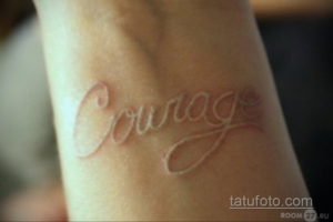 Фото тату белой надписи "Courage" на руке. Изящный шрифт и вдохновляющее слово делают эту татуировку особенной.