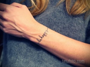 Фото тату: надпись "be happy" изящным шрифтом на запястье. Позитивная и вдохновляющая татуировка.