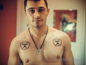 Фото татуировки СССР на груди мужчины, выполненной в черно-белых тонах с изображением значка и креста.