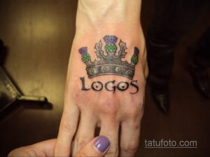 Фотография татуировки с изображением короны и надписи 'Logos', выполненной на руке. Стильный и оригинальный рисунок.