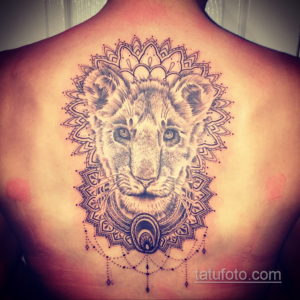 Фото тату на спине: голова льва в центре мандалы, выполненная в технике дотворк. Детализированный и символичный рисунок татуировки.