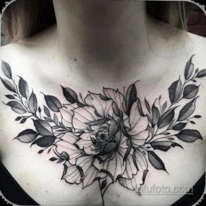 Фото тату на груди с крупными пионами и листьями, выполненное в технике black and grey. Детализированный рисунок татуировки.