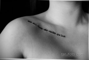 Фото тату: черная надпись "Not all those who wander are lost" на плече. Минималистичный шрифт и расположение создают стильный и мотивирующий образ.