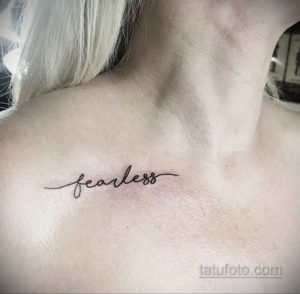 Фото тату: надпись 'fearless' выполненная тонким шрифтом, расположена на шее. Простой и стильный рисунок татуировки.
