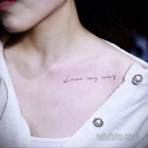 Фото тату: изящная надпись 'Love my way' выполнена на груди девушки, демонстрируя минималистичный стиль и уверенность в себе.