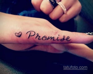 Фото тату: надпись "Promise" с изображением сердца на пальце руки. Романтичный и минималистичный рисунок татуировки.