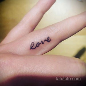 Фото тату: надпись 'love' на пальце, выполненная черными чернилами. Простой и лаконичный дизайн для тех, кто ценит любовь.