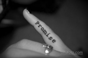 Фото тату надписи 'Promise' на пальце руки. Лаконичный рисунок татуировки, выполненный черными чернилами.