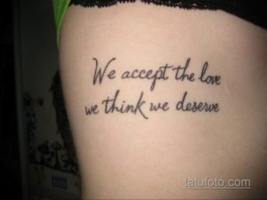 Фото тату: татуировка с фразой "We accept the love we think we deserve" на боку. Черно-белый рисунок татуировки, каллиграфический стиль, мотивационный эскиз.