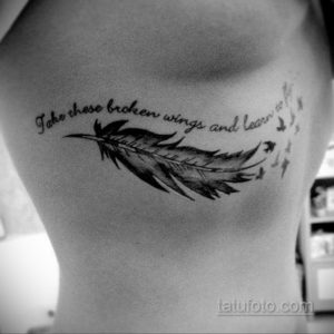 Фото тату: черное перо и надпись 'Take these broken wings and learn to fly' на боку. Красивый рисунок татуировки для девушек.
