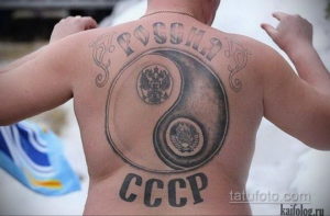 Фото тату на спине с изображением символа Инь и Ян, в котором вместо традиционных элементов изображены гербы России и СССР.