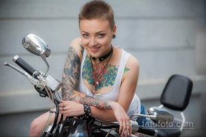 Фото тату на руке и груди девушки: яркие цветы, мотоцикл, реалистичный стиль. Красочная татуировка, привлекающая внимание.