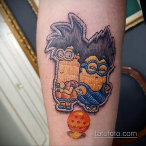 Фото тату: Миньон, стилизованный под персонажа Dragon Ball Z, с прической и одеждой Гоку. Оригинальный рисунок татуировки на руке.