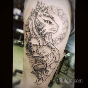 Фото тату в стиле blackwork с изображением египетской богини Бастет и котенка, украшенного сложными геометрическими узорами на руке.