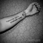 Фото тату: небольшой геометрический бриллиант и надпись 'Tomorrow ain't promised today' на запястье. Черно-белая графика.