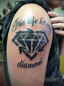 Фото тату: черно-белый бриллиант с надписью "This life is my diamond" на плече. Классический рисунок татуировки.