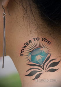 Фото тату: татуировка с изображением голубого бриллианта и надписью 'Power to You' на плече.