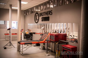Фото современной тату-студии с логотипом "Brothers Studio", профессиональным оборудованием и зеркалами.