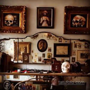 Фото интерьера тату-салона с черепами в рамках, старинными портретами и приглушенным освещением. Мрачная и загадочная атмосфера.