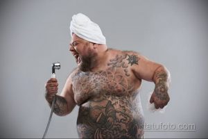 Фото татуировки на теле мужчины: масштабный рисунок в японском стиле, покрывающий большую часть тела. Детализированный рисунок татуировки с использованием черного и серого цветов.