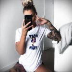 Девушка с татуировками одетая в одну футболку делает селфи стоя на коленях в постели – 08.01.2020 - tatufoto.com