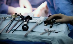 Фото тату с изображением хирургических инструментов на синем покрывале. Реалистичный рисунок скальпелей, зажимов и других инструментов.