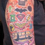 Фото тату на предплечье с логотипами и символами супергероев DC Comics и Marvel, выполненное в ярких цветах и комикс-стиле.