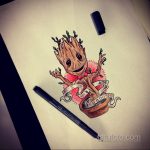 Фото тату Грута из Стражей Галактики с надписью 'I am Groot' на ленте. Татуировка выполнена в ярких, красочных тонах.