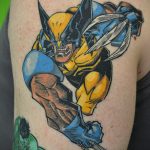 Фото тату Росомахи из X-Men на плече. Динамичный рисунок с выпущенными когтями, яркие цвета и детализированная проработка.