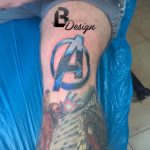 Фото тату логотипа Мстителей на руке. Четкий контур, яркие цвета и надпись 'BDesign' добавляют индивидуальности.