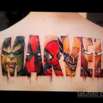 Яркая татуировка на спине с изображением логотипа Marvel, буквы которого заполнены портретами различных супергероев, таких как Халк, Человек-Паук и другие.