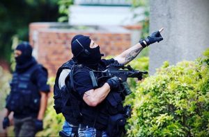 Фото сотрудника спецназа с татуировкой на руке, выполненной в черных тонах. Рисунок татуировки частично виден из-под рукава.