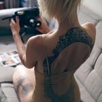 Фото татуировки в виде кружевного узора, расположенного на спине девушки. Тату выполнено в черном цвете с тонкой проработкой деталей.