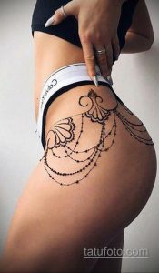 Фото тату на бедрах: изящный рисунок в стиле blackwork, имитирующий кружевное белье. Подчеркивает женственность и сексуальность.