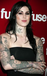 Фото тату известной тату-мастера Kat Von D, демонстрирующее ее обширные татуировки в стиле олд скул и реализм на руках и шее.