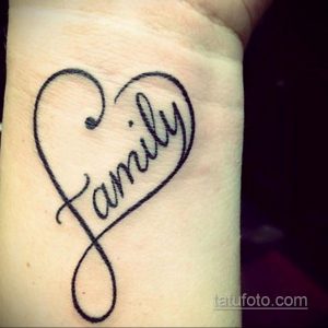Фото тату с надписью "Family" в форме сердца на запястье, выполненное в каллиграфическом стиле. Татуировка выглядит нежно и символизирует любовь к семье.