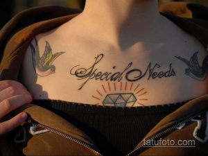 Фото татуировки на ключице, изображающей две ласточки и надпись "Special Needs". Татуировка выполнена в черно-белых тонах.