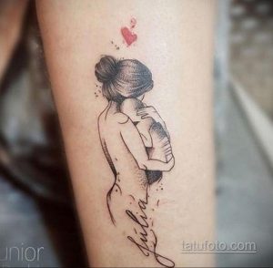 Фото тату: Трогательный рисунок матери, обнимающей ребенка, с именем "Julia" подписью. Идеально для мам, желающих увековечить любовь к своим детям.