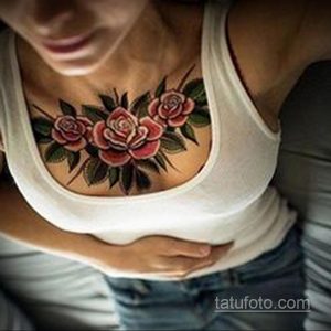 Фото тату: Цветная татуировка с тремя розами на груди женщины. Яркие красные и розовые оттенки создают привлекательный образ.