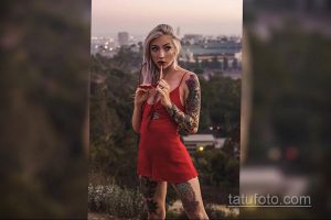 Фото девушки с яркими татуировками на руках и ногах. Цветы, узоры, животные, красочный дизайн, летний образ.