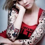 Фото тату: девушка с полностью татуированным телом, демонстрирующая сложный и детализированный тату-арт, включающий бабочек, звезды и надписи.
