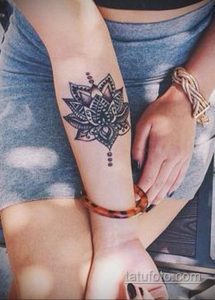 Фото тату: черная мандала с тонкими узорами на внутренней стороне запястья девушки. Детализированный рисунок татуировки в стиле ориентал.