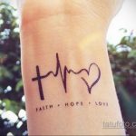 Фото минималистичной татуировки надписью 'Faith, Hope, Love' на запястье. Небольшой рисунок татуировки черными чернилами.