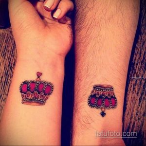 Фото парных тату: красная корона с сердцем на запястье одной руки и красная подушка с сердцем на запястье другой руки.
